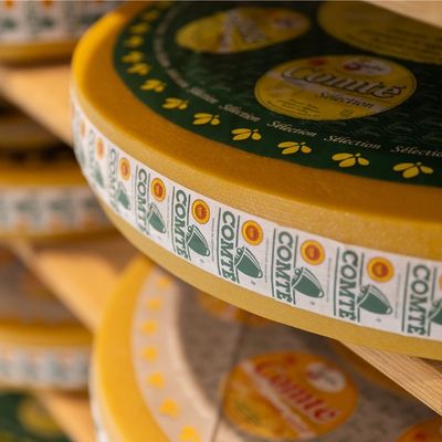 Aged PDO Comté cheese wheels resting on shelves, showcasing one of France’s most iconic cheeses.