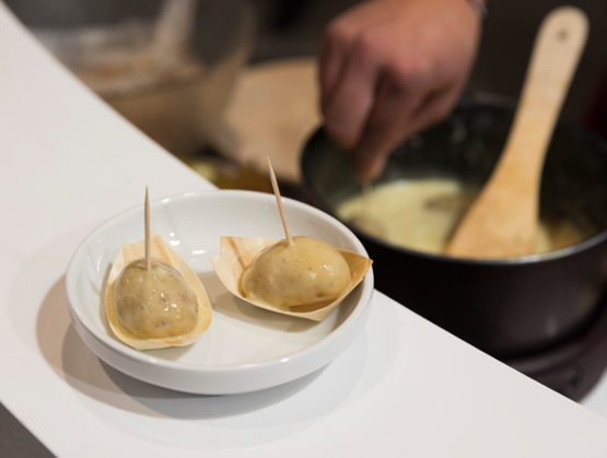 Pommes de terre sur assiette sur lesquels se trouve du fromage fondue