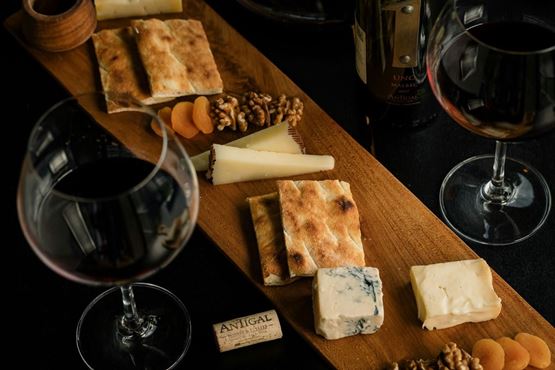 Planche de fromages accompagnée de deux verres de vin
