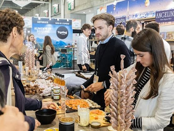 Exposants et visiteurs discutants sur un stand au salon Gourmet Selection