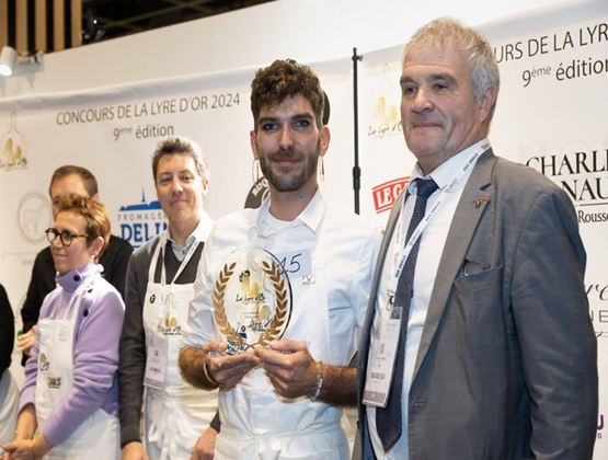 Lauréat tenant un trophée aux côtés d’un professionnel lors du concours de la Lyre d’Or 2024.