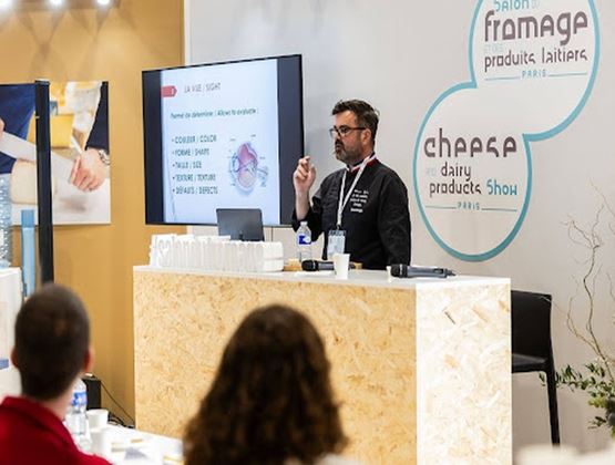 Intervenant présentant une conférence devant un public au Salon du Fromage et des Produits Laitiers.