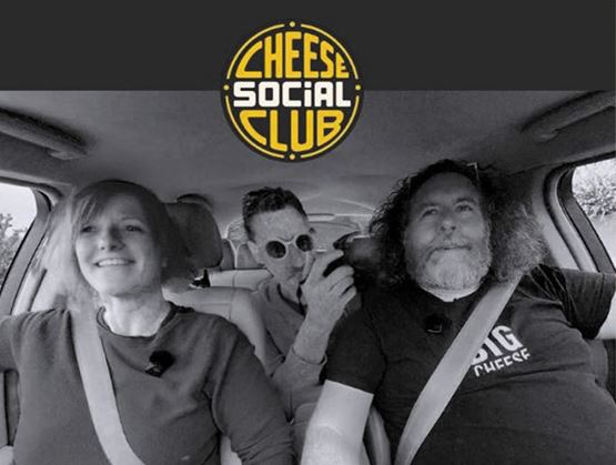 Visuel en noir et blanc du Cheese Social Club, montrant trois personnes assises dans une voiture avec le logo « Cheese Social Club » en haut de l’image.