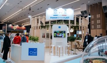 Stand Franceterre de Lait au Salon du fromage et des produits laitiers, avec espace d’accueil, écran de présentation et visiteurs professionnels.