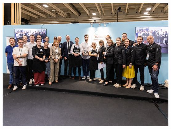 Photo de groupe sur scène lors d’un salon professionnel, avec les lauréats tenant leurs trophées.