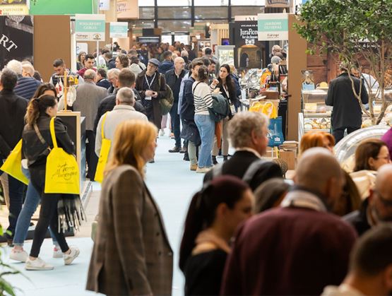 Visiteurs parcourant les allées d’un salon professionnel animé, entre stands et espaces d’exposition.