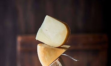Morceaux de fromage empilés en équilibre sur une table en bois.