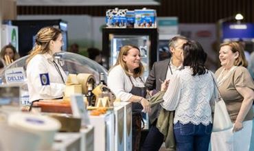 Professionnelles échangeant sur un stand de fromages lors d’un salon professionnel.