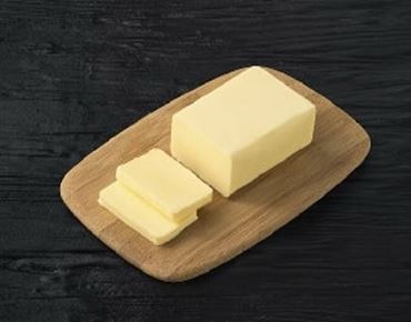 Lump of butter on a wooden tray. 