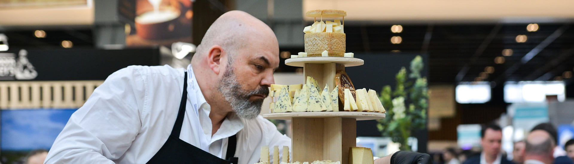 A cheesemonger preparing a cheese composition.