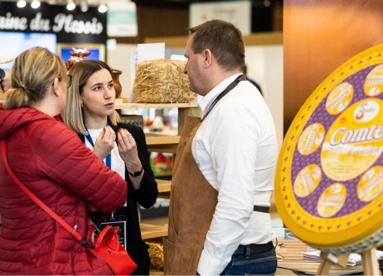 exposant qui discute avec deux visiteurs sur le salon