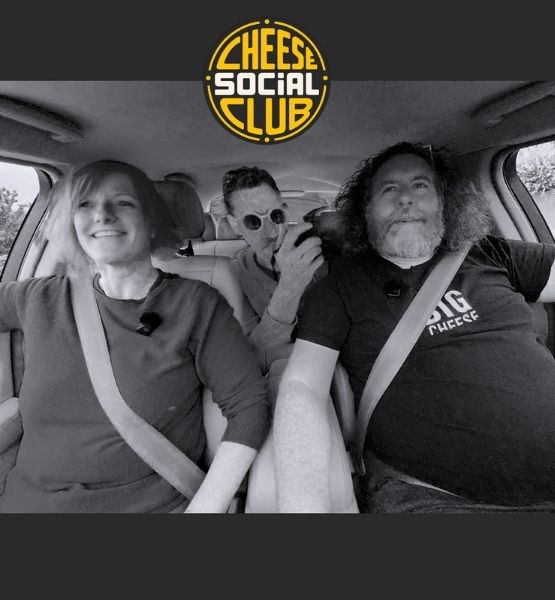 Trois personnes souriantes portant la ceinture de sécurité dans une voiture avec le logo Cheese Social Club.